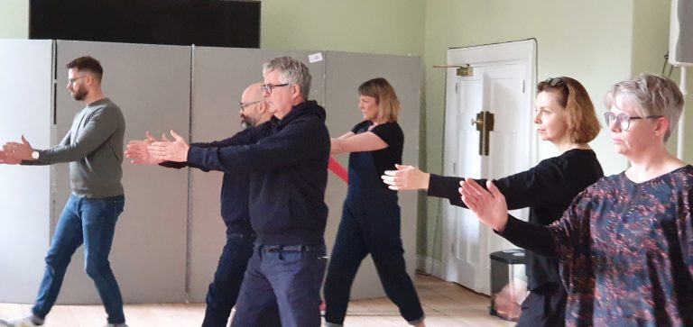 Group practising with arms extended